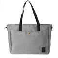 Gray tote bag with black straps, front pocket, and snap button closure
