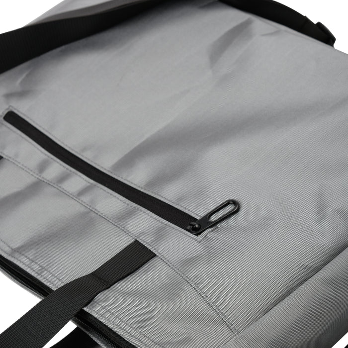 Close-up of a gray fabric tote bag with black zipper pocket and strap