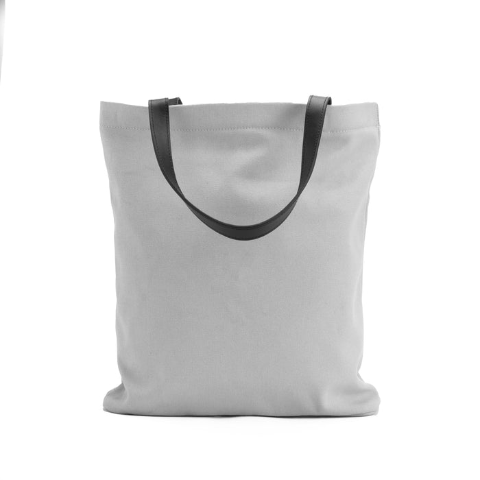 Minimalist light gray canvas tote bag with black handles on white background
