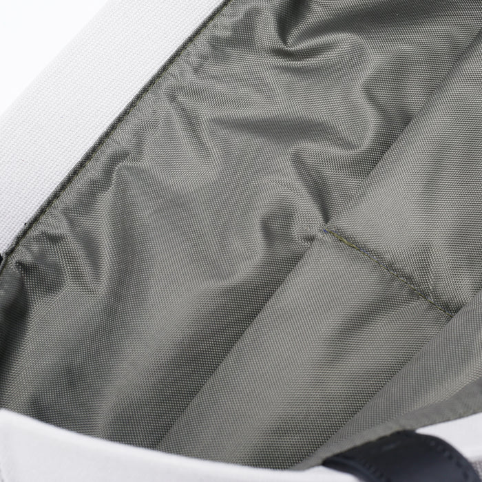Close-up of grey fabric interior compartment of a bag with white outer edge