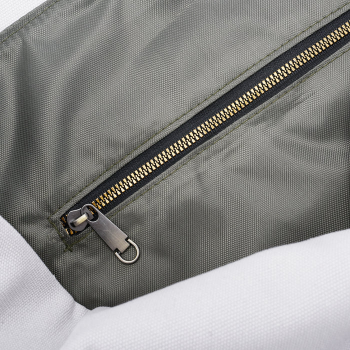 Close-up of a gray fabric bag with a metal zipper and textured material