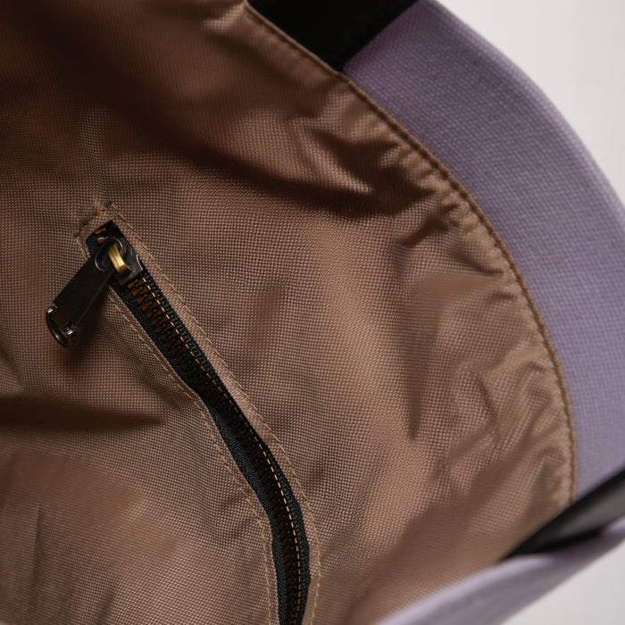 Close-up of a bag interior with brown fabric lining and zippered pocket